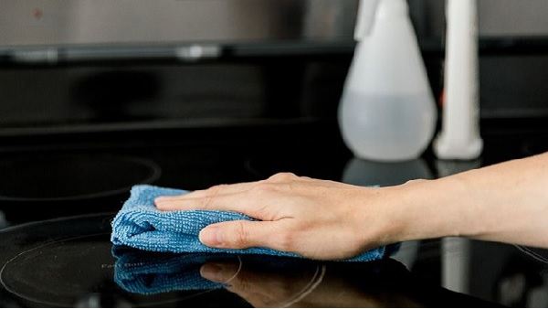 Dùng chiếc khăn mềm hơi ẩm lau sạch dung dịch vệ sinh trên bề mặt bếp từ